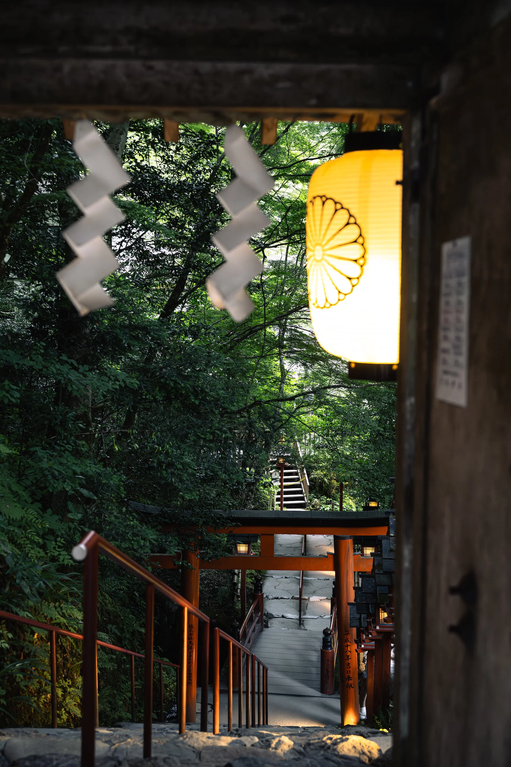 A lantern over shrine steps at dusk
