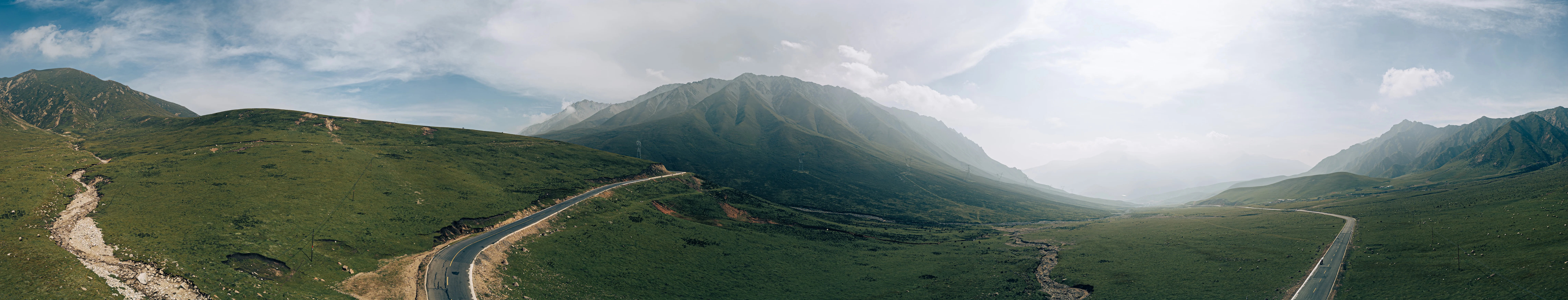Panorama of a mountain road across Qilian meadows